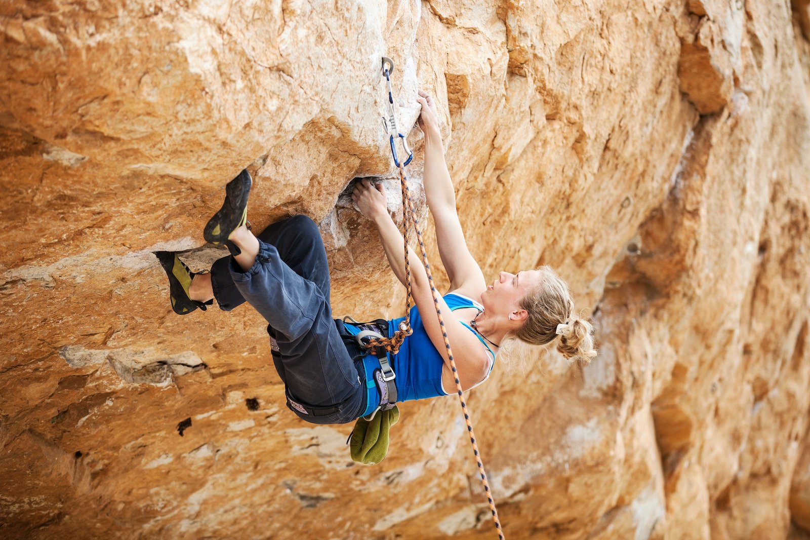 Rock climber struggling to make next movement up