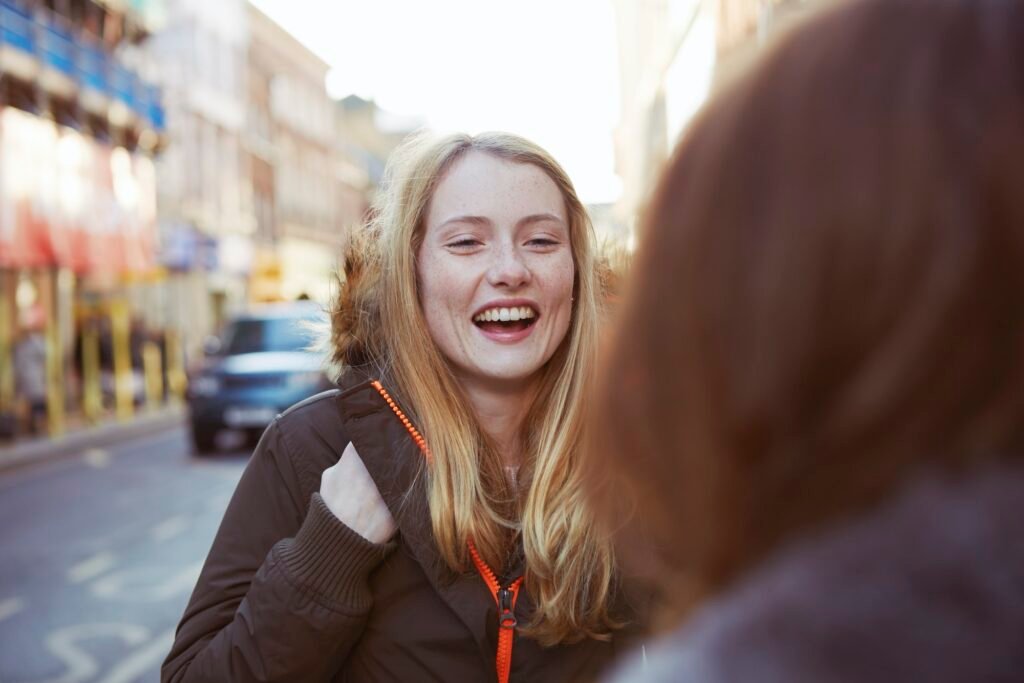 Two female friends talking in street