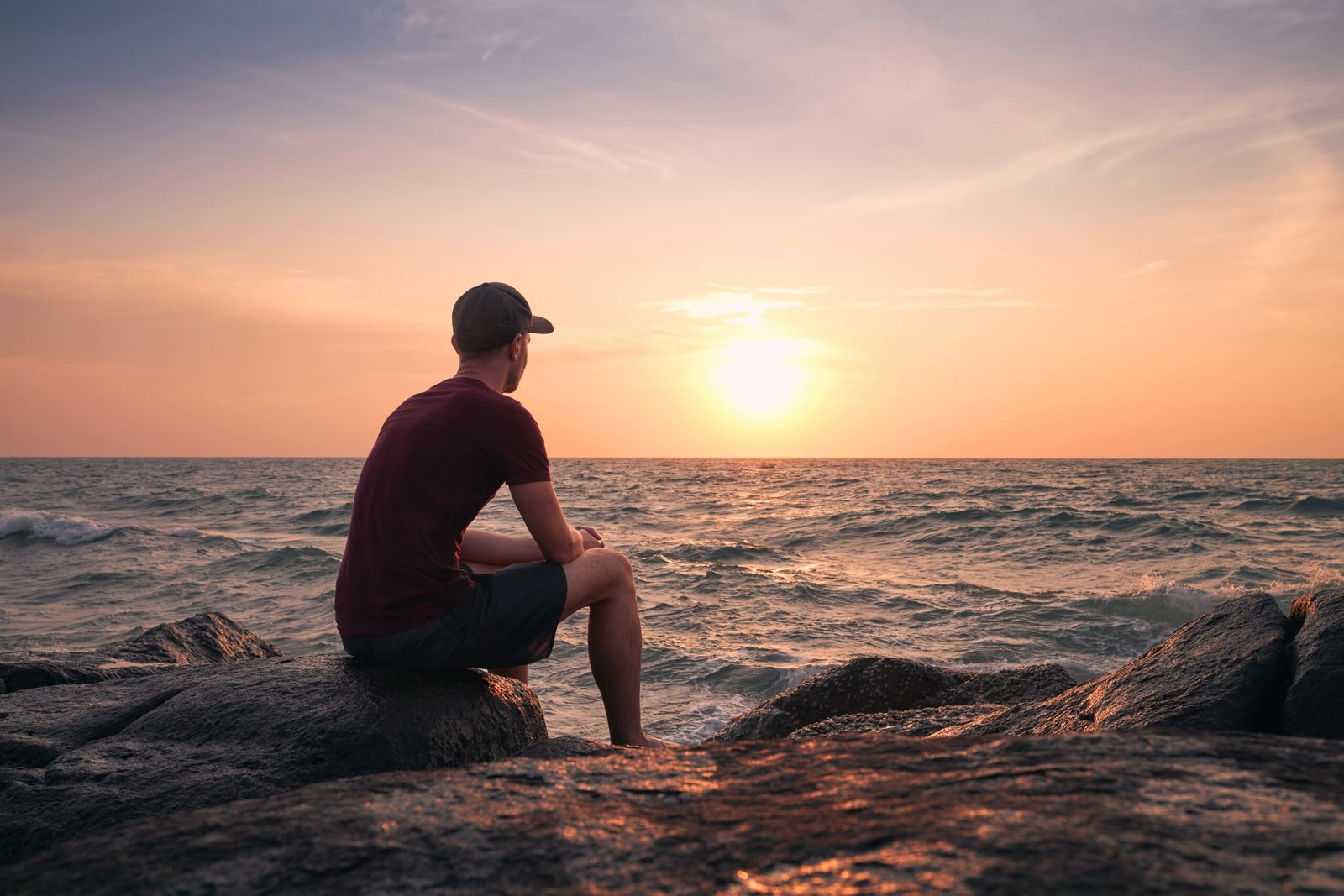 Man watching beautiful sunset over ocean